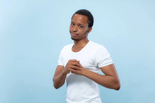 Halblanges Nahaufnahme-Porträt eines jungen Mannes auf blauem Hintergrund. — Stockfoto