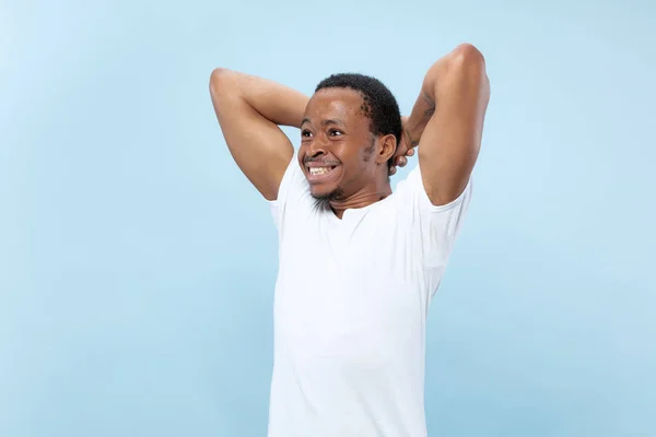 Media longitud primer plano retrato de hombre joven sobre fondo azul . — Foto de Stock