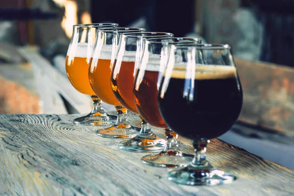 Glasses of different kinds of beer on wooden background — Stock Photo, Image