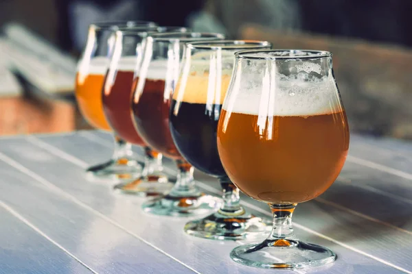 Glazen van verschillende soorten bier op houten achtergrond — Stockfoto