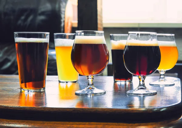 Vasos de diferentes tipos de cerveza sobre fondo de madera —  Fotos de Stock