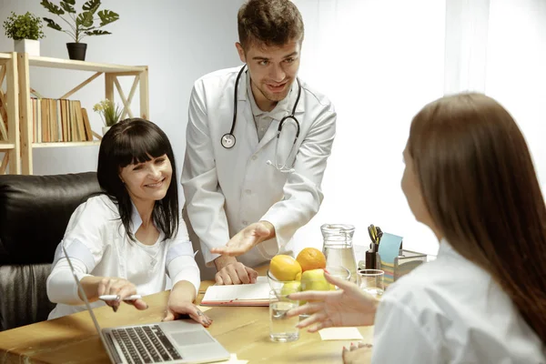 Nutricionistas sonrientes mostrando un plan de dieta saludable para el paciente —  Fotos de Stock