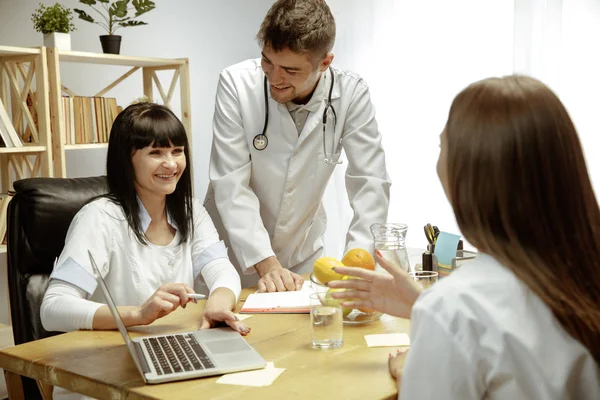 Nutricionistas sonrientes mostrando un plan de dieta saludable para el paciente —  Fotos de Stock
