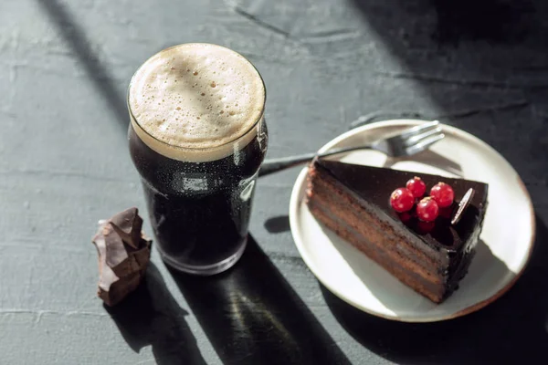 石のテーブルの背景に暗いビールのガラス — ストック写真