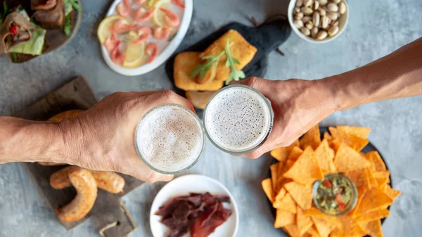 Vista superior de vasos de cerveza con espuma en la parte superior y deliciosos aperitivos — Foto de Stock