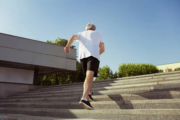 Senior man som löpare med armband eller Fitness Tracker på stadens gatan — Stockfoto