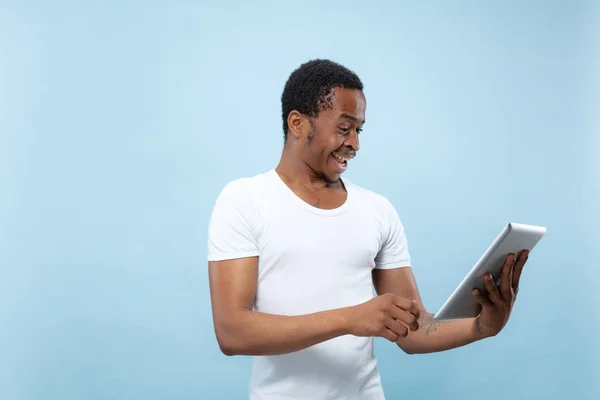 Halblanges Nahaufnahme-Porträt eines jungen Mannes auf blauem Hintergrund. — Stockfoto