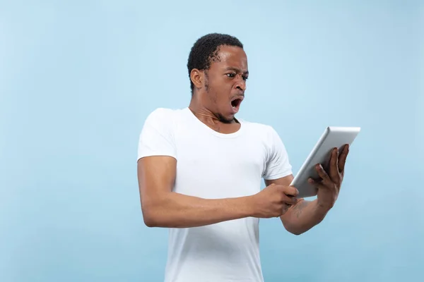 Halblanges Nahaufnahme-Porträt eines jungen Mannes auf blauem Hintergrund. — Stockfoto