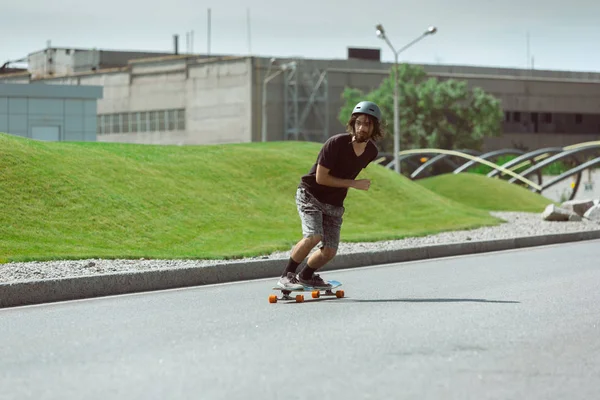 Skateboarder doing a trick at the citys street in sunny day — Stock Photo, Image