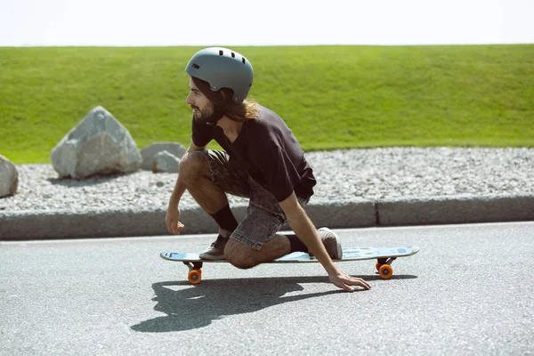 Skateboarder macht bei sonnigem Wetter einen Trick auf der Straße — Stockfoto