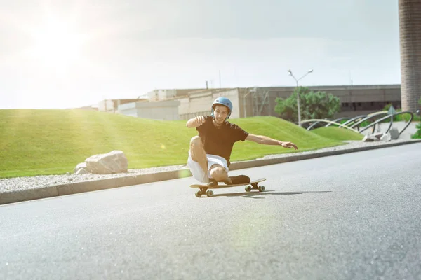 Skateboarder doing a trick at the citys street in sunny day — Stock Photo, Image