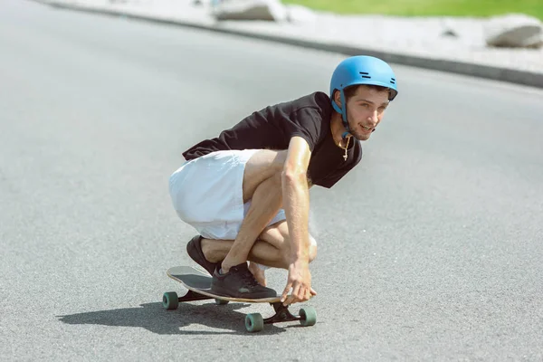 Skateboarder macht bei sonnigem Wetter einen Trick auf der Straße — Stockfoto