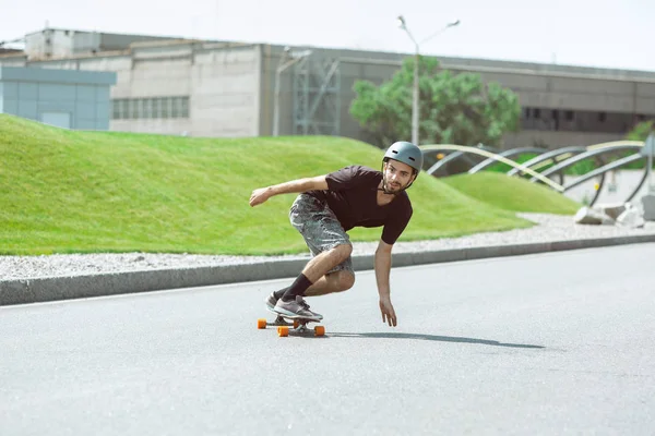 Skateboarder doing a trick at the citys street in sunny day — Stock Photo, Image