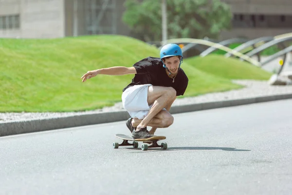 Skateboarder robi sztuczkę na ulicy miejskich w słoneczny dzień — Zdjęcie stockowe