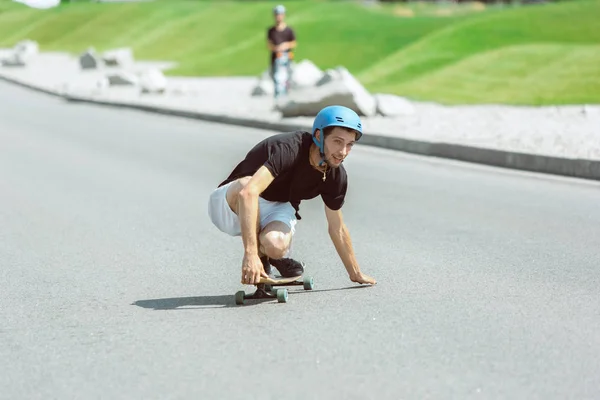 Skateboarder robi sztuczkę na ulicy miejskich w słoneczny dzień — Zdjęcie stockowe