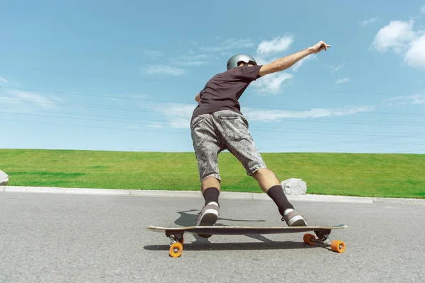 Skateboarder doing a trick at the citys street in sunny day — Stock Photo, Image