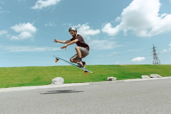 Скейтбордист выполнял трюк на городской улице в солнечный день — стоковое фото