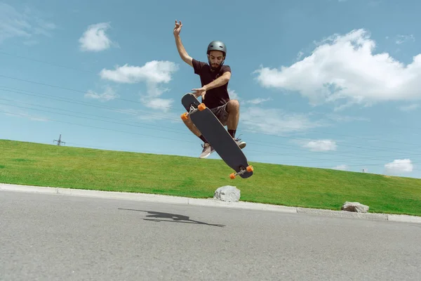 Skateboarder doing a trick at the citys street in sunny day — Stock Photo, Image