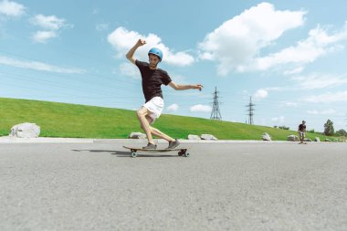 Skateboarders güneşli bir gün içinde kentin sokakta bir hüner yapıyor