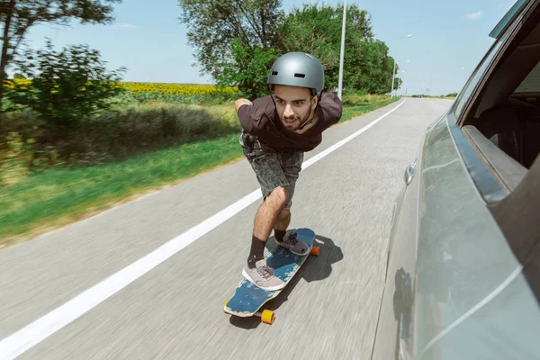 Skateboarder doing a trick at the citys street in sunny day — Stock Photo, Image