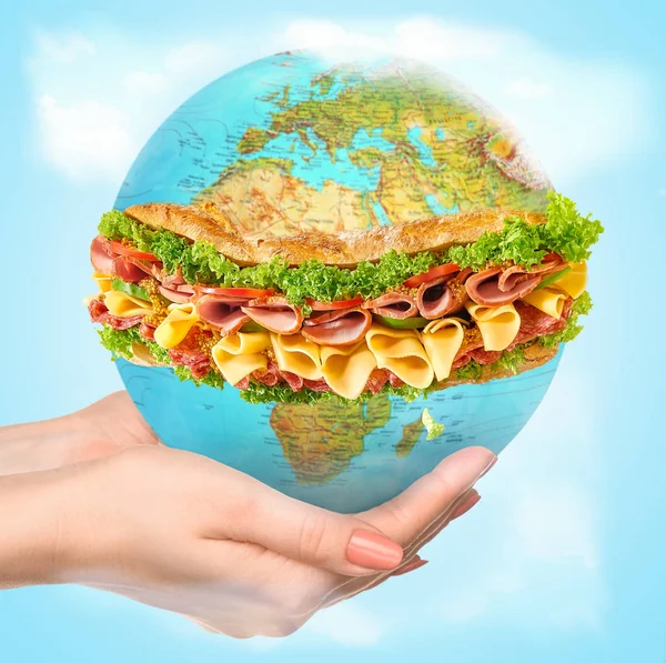 Save healthy food - female hands holding a globe as a sandwich