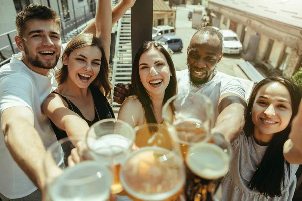 Joven grupo de amigos bebiendo cerveza y celebrando juntos — Foto de Stock