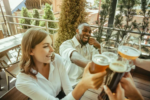 Joven grupo de amigos bebiendo cerveza y celebrando juntos — Foto de Stock