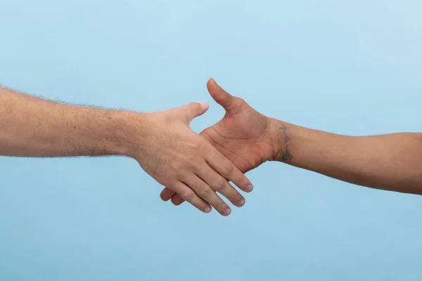 Close up shot of human holding hands isolated on blue studio background.