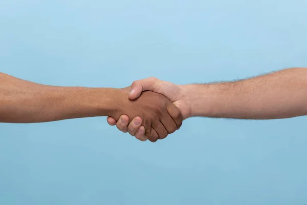 Primer plano de humanos tomados de las manos aislados sobre fondo azul estudio . — Foto de Stock