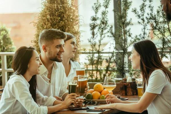 ビールを飲んで一緒にお祝いする友人の若いグループ — ストック写真