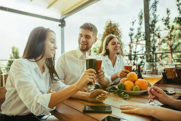 Joven grupo de amigos bebiendo cerveza y celebrando juntos — Foto de Stock