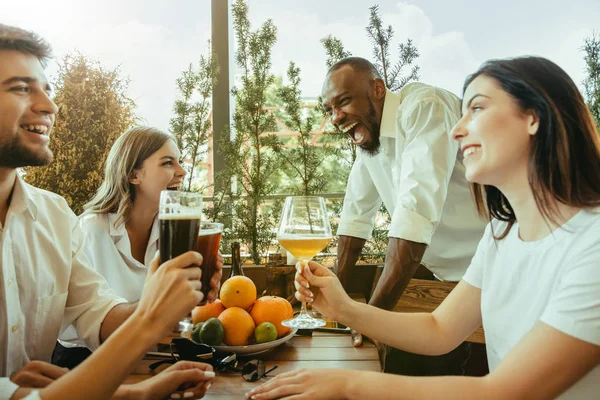 Joven grupo de amigos bebiendo cerveza y celebrando juntos — Foto de Stock