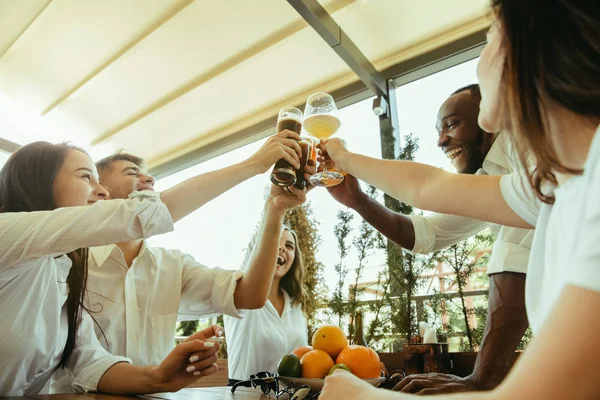 दोस्तों का युवा समूह बीयर पी रहा है और एक साथ मना रहा है — स्टॉक फ़ोटो, इमेज