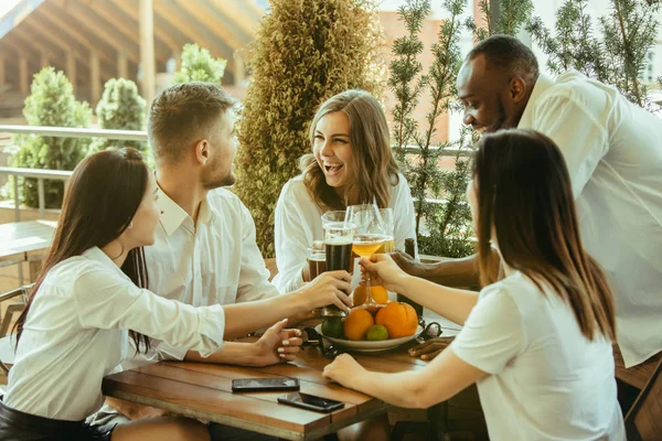 Молода група друзів п'ють пиво і святкують разом — стокове фото