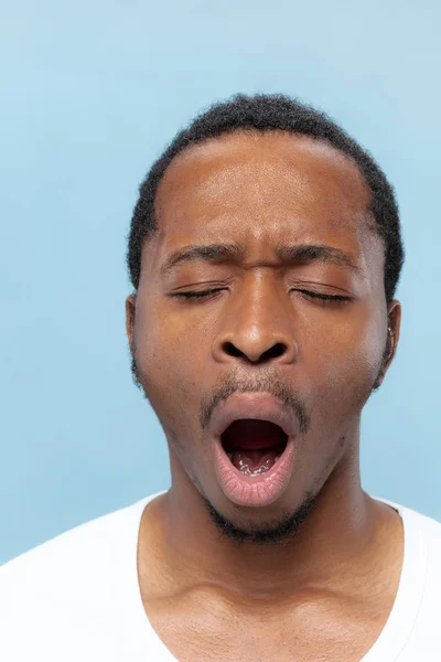 Nahaufnahme Porträt eines jungen Mannes auf blauem Hintergrund. — Stockfoto