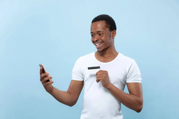 Media longitud primer plano retrato de hombre joven sobre fondo azul . — Foto de Stock