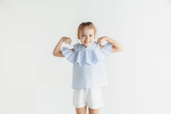 Petite fille souriante posant en vêtements décontractés sur fond de studio blanc — Photo
