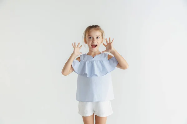 Kleines lächelndes Mädchen posiert in lässiger Kleidung auf weißem Studiohintergrund — Stockfoto