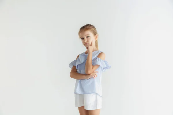 Kleines lächelndes Mädchen posiert in lässiger Kleidung auf weißem Studiohintergrund — Stockfoto