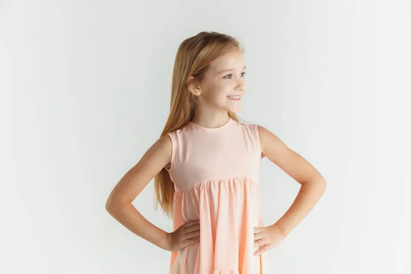 Pequena menina sorridente posando em vestido no fundo do estúdio branco — Fotografia de Stock