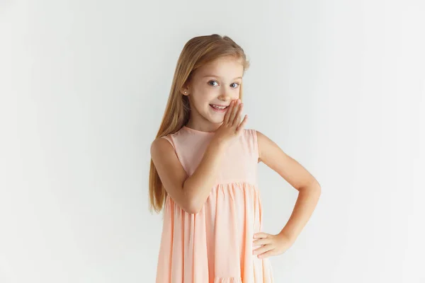 Pequena menina sorridente posando em vestido no fundo do estúdio branco — Fotografia de Stock