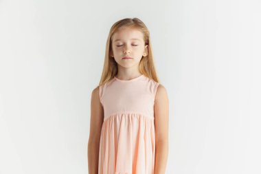 Beyaz stüdyo arka planda elbise içinde poz veren küçük gülümseyen kız