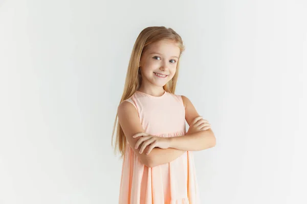 Pequena menina sorridente posando em vestido no fundo do estúdio branco — Fotografia de Stock