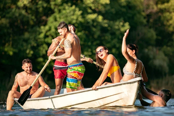 Fröhliche Gruppe von Freunden, die Spaß haben, lachen und im Fluss schwimmen — Stockfoto