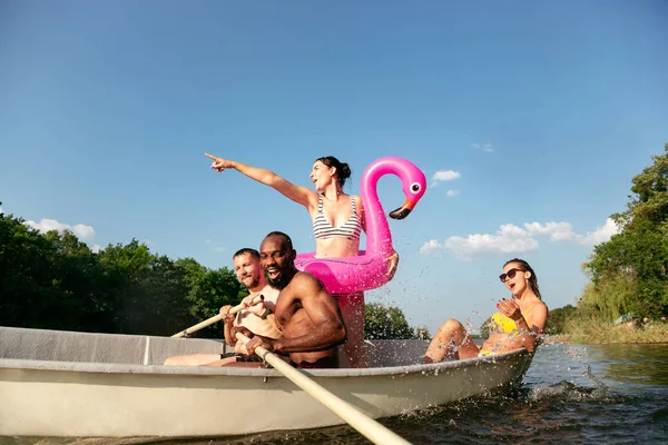 Fröhliche Gruppe von Freunden, die Spaß haben, lachen und im Fluss schwimmen — Stockfoto