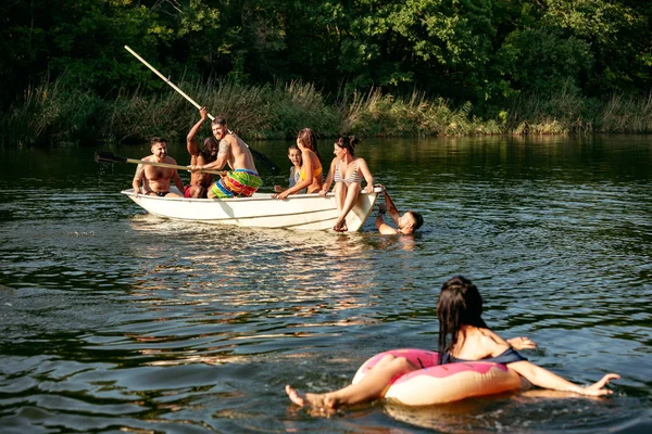 Feliz grupo de amigos divirtiéndose, riendo y nadando en el río —  Fotos de Stock