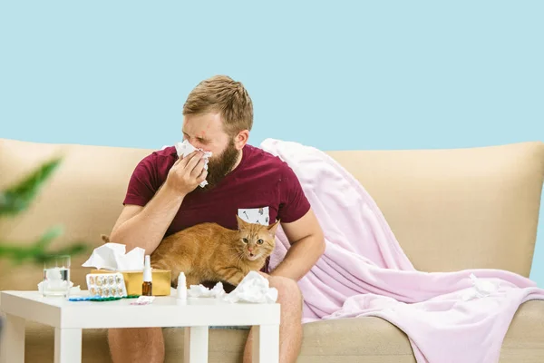 Mladý muž trpící alergií na kočičí vlasy — Stock fotografie
