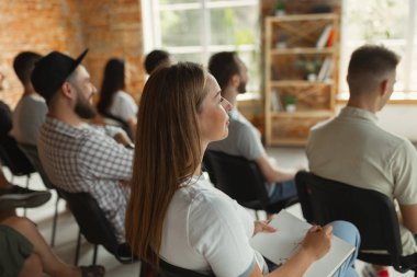 Üniversite atölyesinde salonda sunum dinleyen öğrenciler