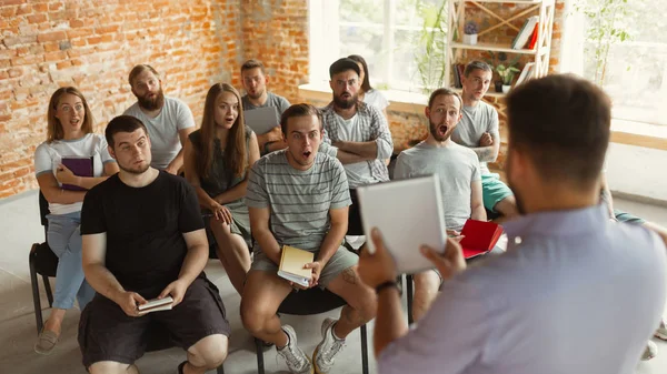 Mužský reproduktor, který dává prezentaci na univerzitní workshop v hale — Stock fotografie