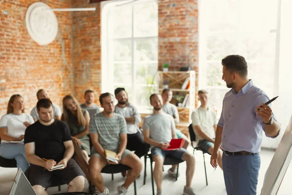 Mužský reproduktor, který dává prezentaci na univerzitní workshop v hale — Stock fotografie